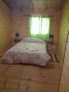 ラゴ・プエロにあるMi Luciの丸太小屋のベッドのある寝室