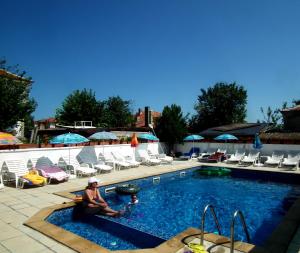 a woman sitting in a pool at a resort at Guest House Olimpiya in Sveti Vlas