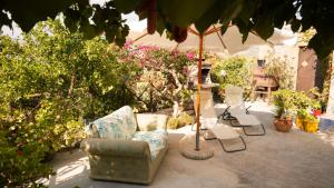 eine Terrasse mit Stühlen, Sonnenschirm und Pflanzen in der Unterkunft Case Troccoli in Caltabellotta