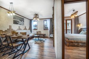 a bedroom with a bed and a dining room with a table at Host2U Authentic Bansko Apartment - Free Parking in Bansko