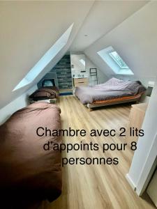 een kamer met 2 bedden op een zolder bij Piscine intérieure privée chauffée spa toute lannee disponible minimum 2 nuits in Ploudaniel +33 foto's