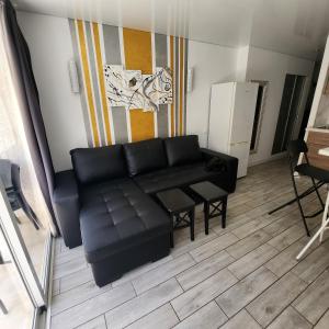 a living room with a black couch and a table at Cozy apartment with balcony, pool and Wifi in Playa de Las Americas in Playa de las Americas