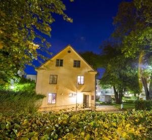 韦克舍Södervillan的一栋亮着灯的大黄色房子