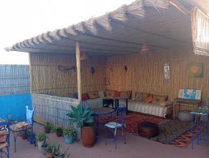 an outdoor living room with a couch and tables and chairs at Studio Dar ziane in El Jadida