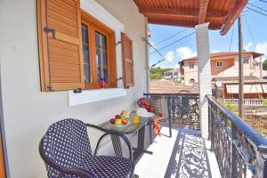 a patio with a table and chairs on a balcony at KarolinaHouse in Ágios Matthaíos