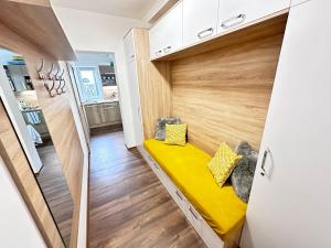 a small room with a yellow bench in the middle at Apartmán Orech in Belá