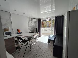 a kitchen and living room with a table and chairs at Cozy apartment with balcony, pool and Wifi in Playa de Las Americas in Playa de las Americas +14 photos