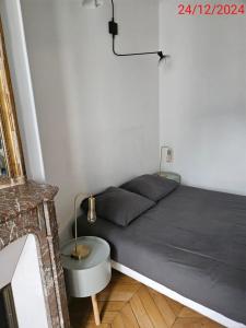a bed in a small room with a table at Cosy private room in Shared appartment - 1 person only ! in Paris