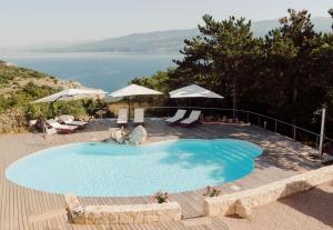 a large blue swimming pool with a view of the water at Casa Ulivo in Šilo