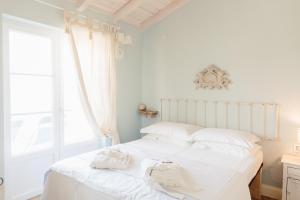a bedroom with a white bed with white pillows at Casa Ulivo in Šilo +24 photos