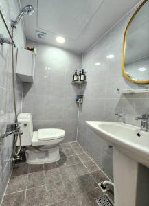 a bathroom with a toilet and a sink and a mirror at Shinchon Stay in Seoul +31 photos