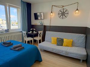 a bedroom with a bed and a couch and a table at Good Night in Szczecin in Szczecin