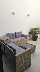 two wicker chairs and a couch in a room at City Center Villa in Faro