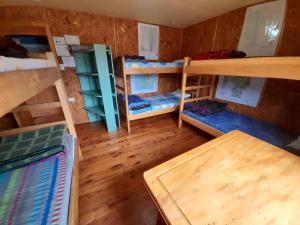 a room with several bunk beds and a table at El Mosco in Villa O'Higgins
