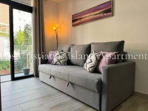 un sofá sentado en una sala de estar junto a una ventana en Los Cristianos Island Apart, en Los Cristianos 29 fotos más