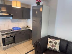 a living room with a couch and a kitchen at Light Side Self Checkin available in Sarcelles