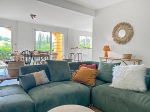 a living room with a blue couch with colorful pillows at Immersion Naturelle à Castelnaud in Castelnaud-de-Gratecambe