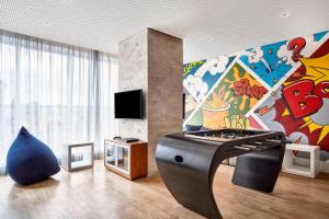 a living room with a large painting on the wall at Sheraton Santos Hotel in Santos
