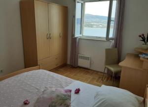 een slaapkamer met een bed en een groot raam bij Apartman Vinka in Trogir
