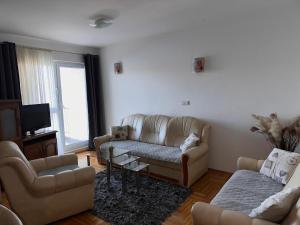 een woonkamer met twee banken en een tv bij Apartman Vinka in Trogir