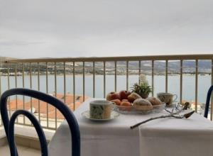 een tafel met een fruitschaal en kopjes op een balkon bij Apartman Vinka in Trogir