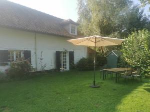 a table and umbrella in the yard of a house at Le Pâtis Piou in Alette