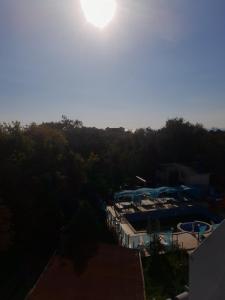 a view of a pool with the sun in the sky at Apartaments Diva in Varna City
