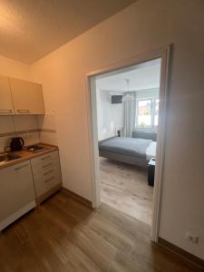 a room with a bedroom with a bed and a kitchen at Maritime Einliegerwohnung in Schwaan
