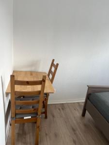 a wooden table and two chairs in a room at Maritime Einliegerwohnung in Schwaan