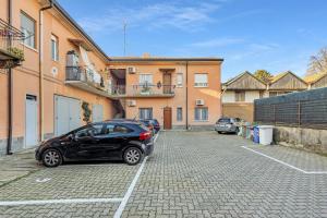 ein Auto, das auf einem Parkplatz vor einem Gebäude geparkt ist in der Unterkunft La Corte alle Porte di Milano in Paderno Dugnano