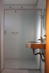 La salle de bains est pourvue d'un lavabo et d'une douche. dans l'établissement Hotel Flamboyant, à Itaquaquecetuba