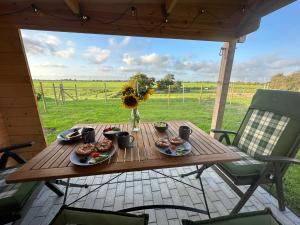 a wooden table with food and flowers on a patio at Haus Treibsel in Dagebüll