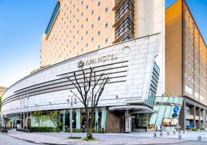 a building with a sign on the front of it at APA Hotel Kanazawa Ekimae in Kanazawa