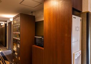 a kitchen with a refrigerator and a microwave at APA Hotel Kanazawa Ekimae in Kanazawa