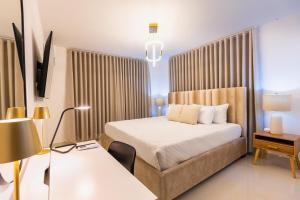 a bedroom with a bed and a desk with a lamp at Modern 3BR! 9fl, King Bed! Sti!, in Santiago de los Caballeros +54 photos