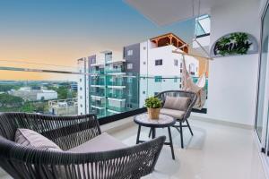 a balcony with two chairs and a table at Modern 3BR! 9fl, King Bed! Sti!, in Santiago de los Caballeros