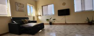 A television and/or entertainment centre at MEETING POINT HOSTEL-Praia Group Reservations