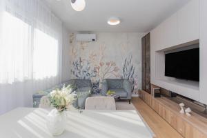a living room with a vase of flowers on a table at Luxury Apartment Providenca with Private Rooftop Terrace in Podstrana