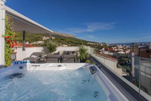 a hot tub on the balcony of a house at Luxury Apartment Providenca with Private Rooftop Terrace in Podstrana