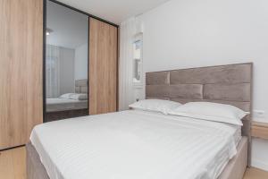 a bedroom with a large white bed and a mirror at Luxury Apartment Providenca with Private Rooftop Terrace in Podstrana +29 photos
