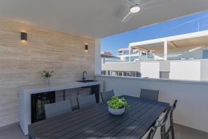 a balcony with a table and chairs and a fireplace at Luxury Apartment Providenca with Private Rooftop Terrace in Podstrana