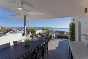 a patio with a table and chairs on a balcony at Luxury Apartment Providenca with Private Rooftop Terrace in Podstrana