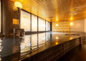 a large pool of water in a room with a large window at APA Hotel Kanazawa Ekimae in Kanazawa