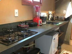 a kitchen counter with a stove and a microwave at Chalé Dona Ramira in Alter do Chao +4 photos