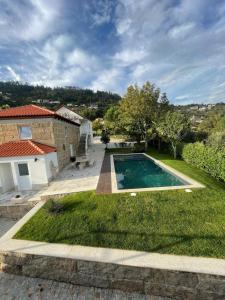 un cortile con piscina e una casa di Quinta do Rio Douro - Turismo Rural Paços de Gaiolo, Porto a Paços de Gaiolo