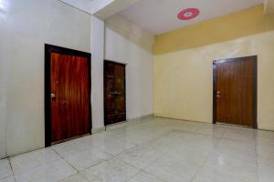 Habitación vacía con 2 puertas y suelo de baldosa. en OYO 90856 HOTEL MANNAT, en Aligarh