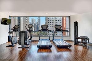 uma academia de ginástica com equipamento cardiovascular e uma grande janela em Sheraton São Paulo WTC Hotel em São Paulo