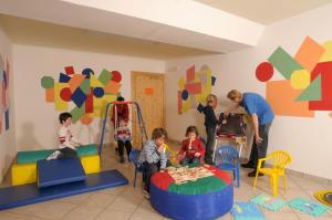 un groupe d'enfants jouant dans une salle de jeux dans l'établissement Hotel Serena, à Badia