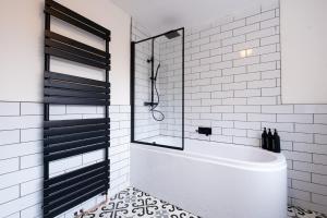 baño blanco con bañera y ducha acristalada en Cosy Home 2 Bedroom House Birkdale, en Southport