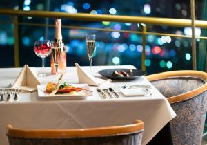a table with a plate of food and glasses of wine at APA Hotel Kanazawa Ekimae in Kanazawa